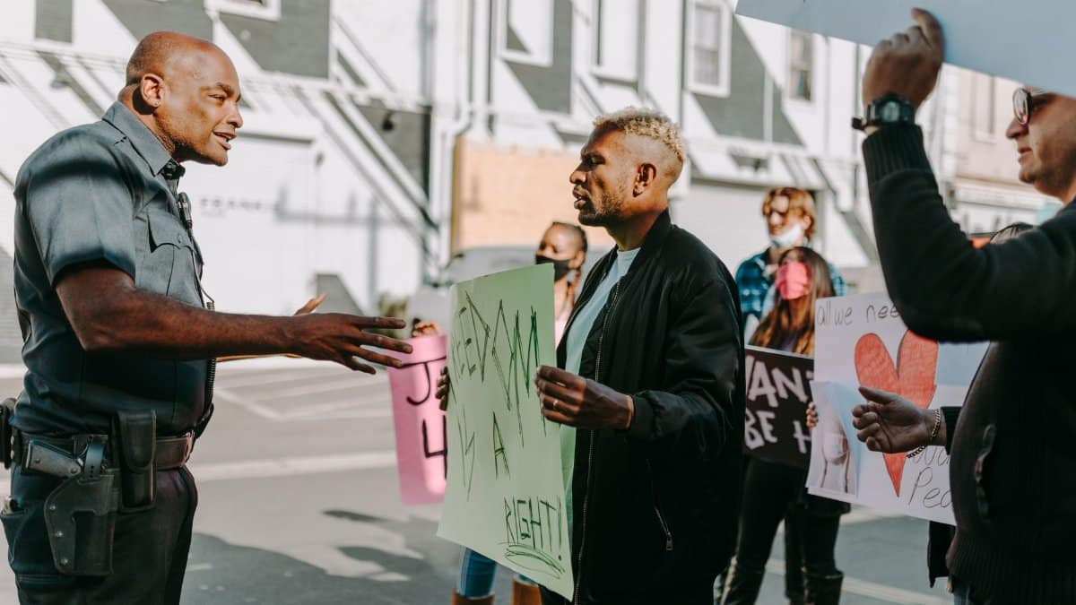 Activists and police engage in a peaceful protest and dialogue on a city street.