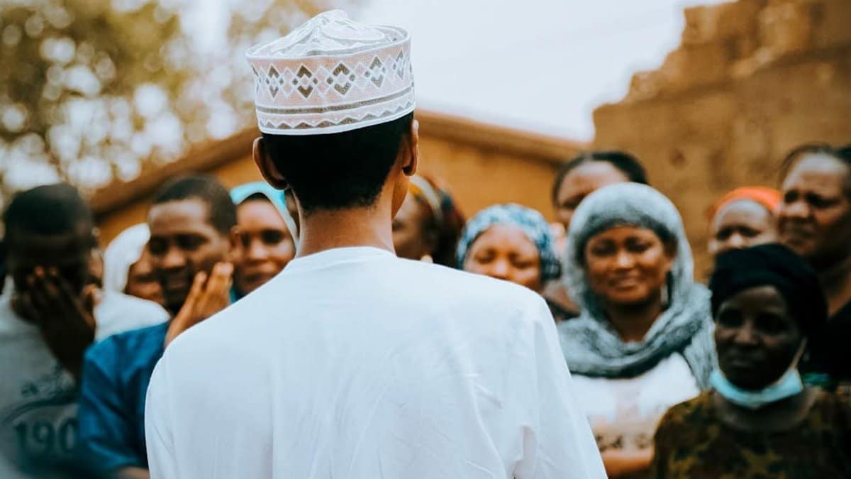 A group of people in traditional attire during an outdoor community gathering in Kaduna, Nigeria.