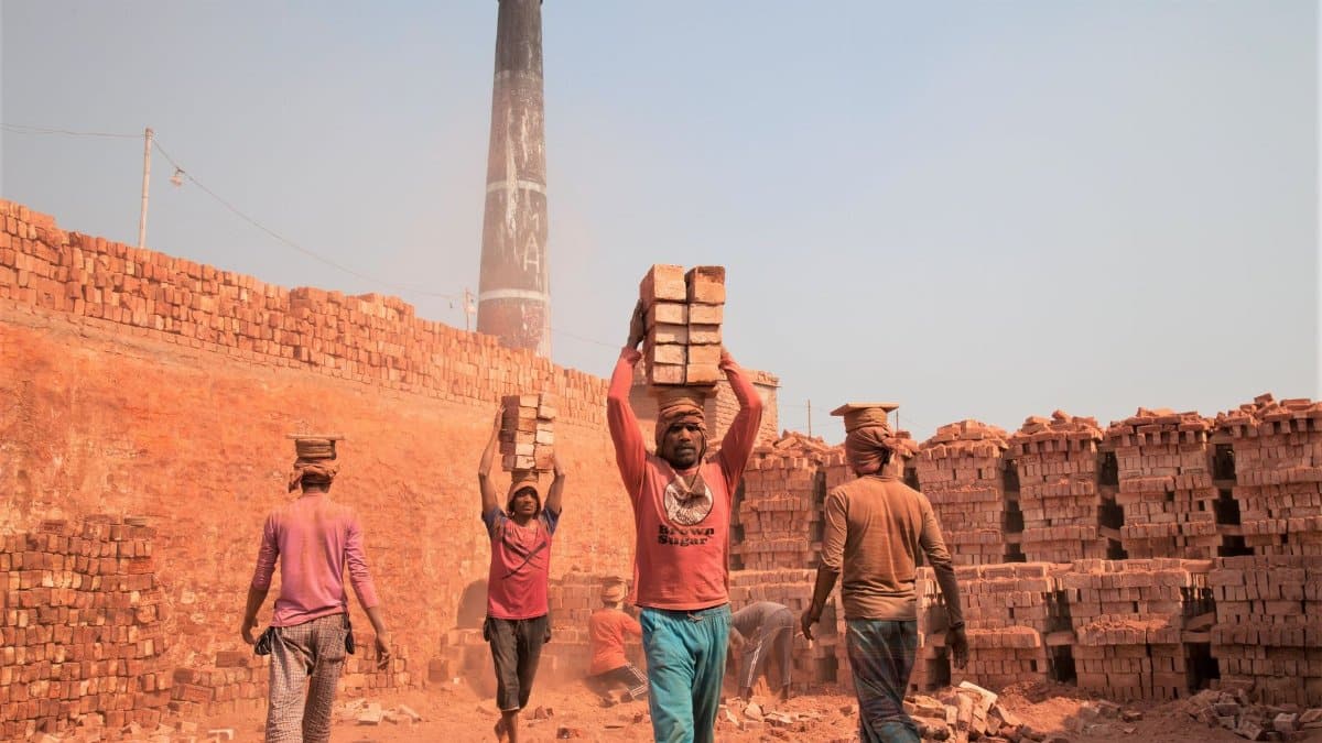 Workers carrying bricks at a construction site in Gabtoli, showcasing manual labor.