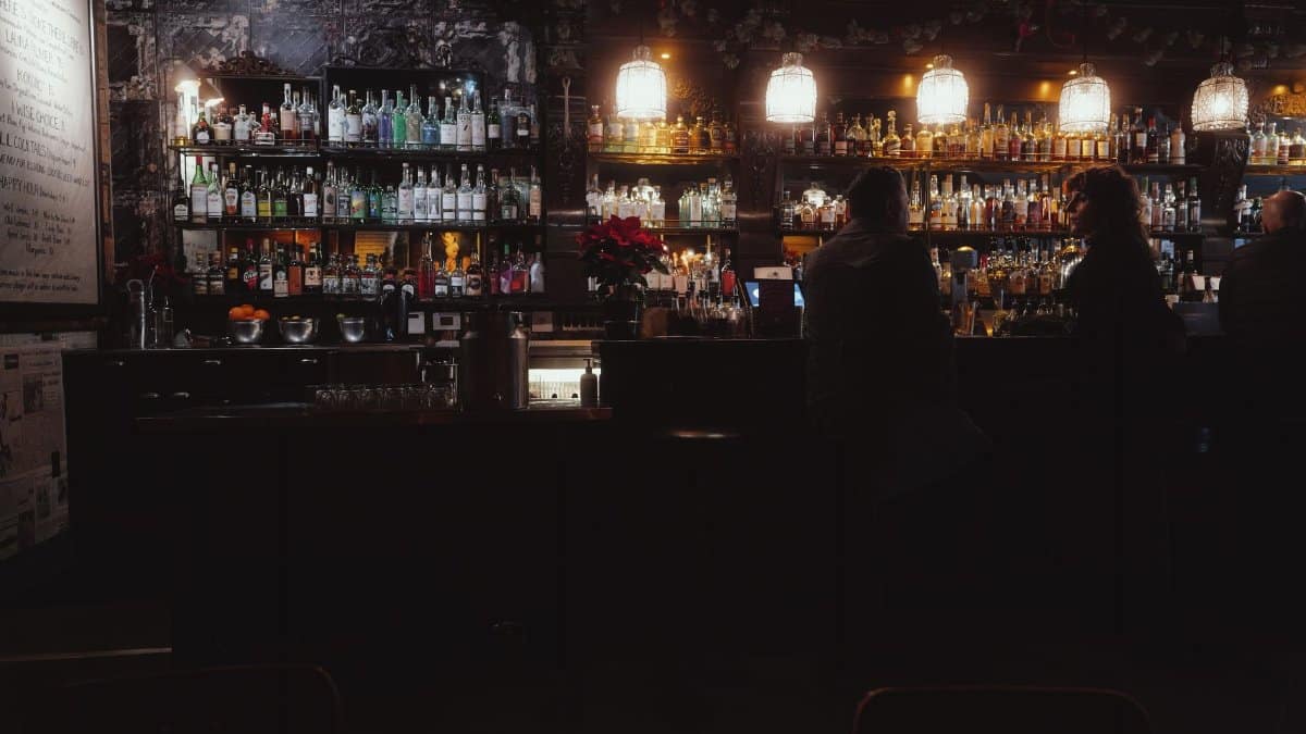 Dimly lit bar with patrons enjoying drinks in San Francisco, warm and inviting atmosphere.
