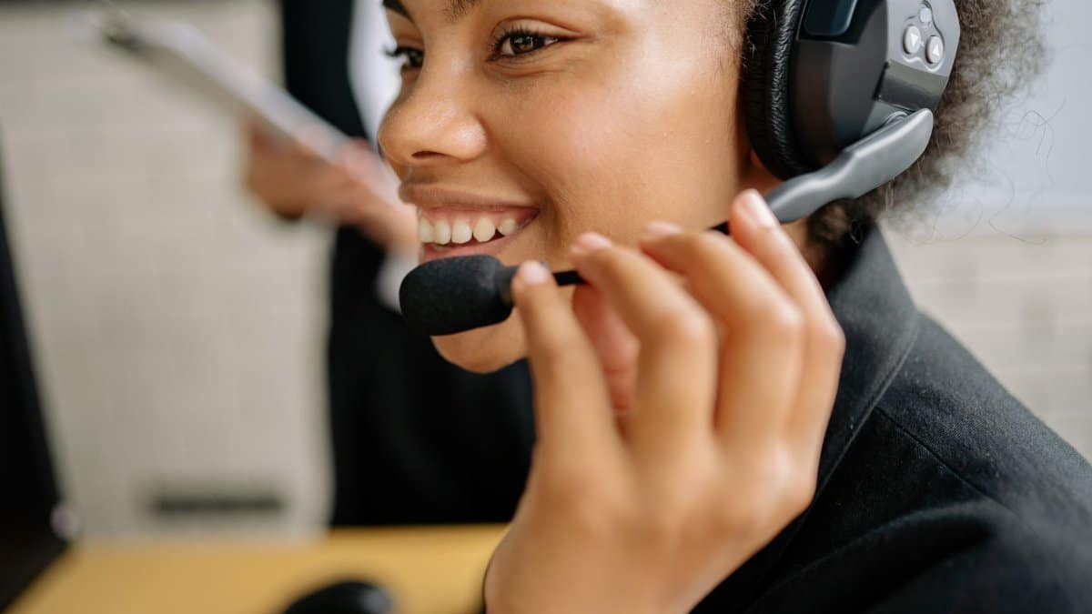 Portrait of a smiling call center agent wearing a headset in an office setting.