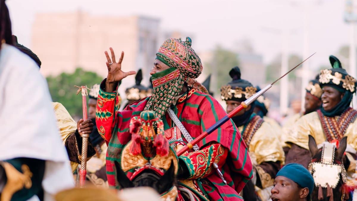 Vibrant African parade featuring elaborately dressed mounted riders in traditional attire, showcasing cultural celebration.