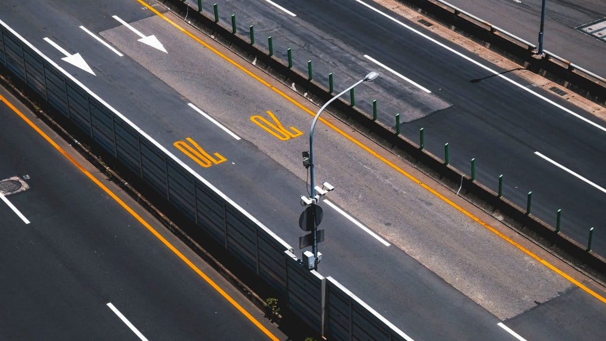 Aerial view of a modern highway with clear lane markings and street lights.