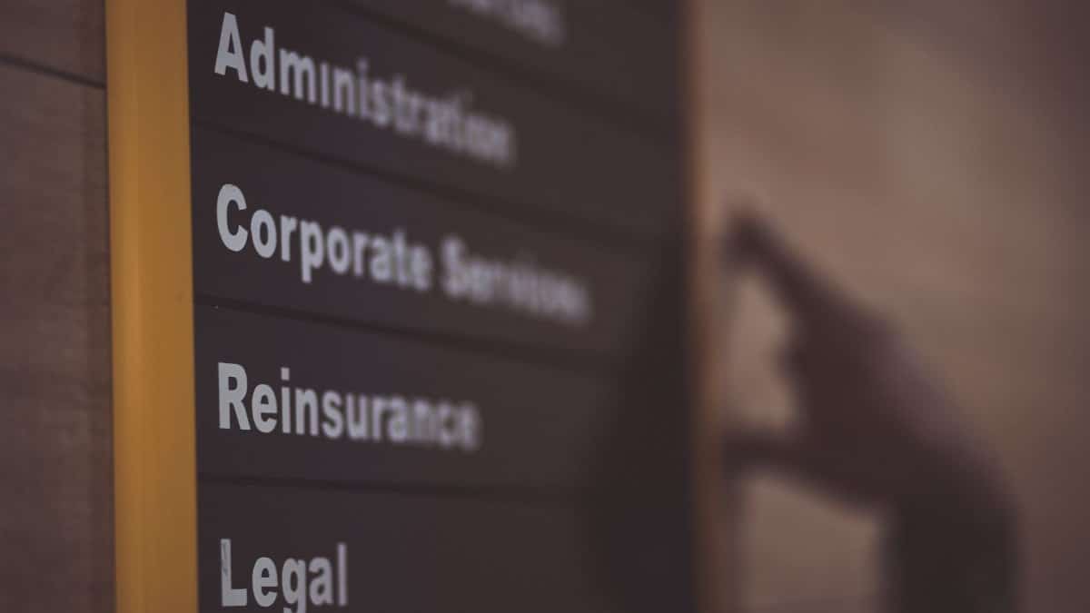 Close-up of an office directory sign showing administration and legal departments.