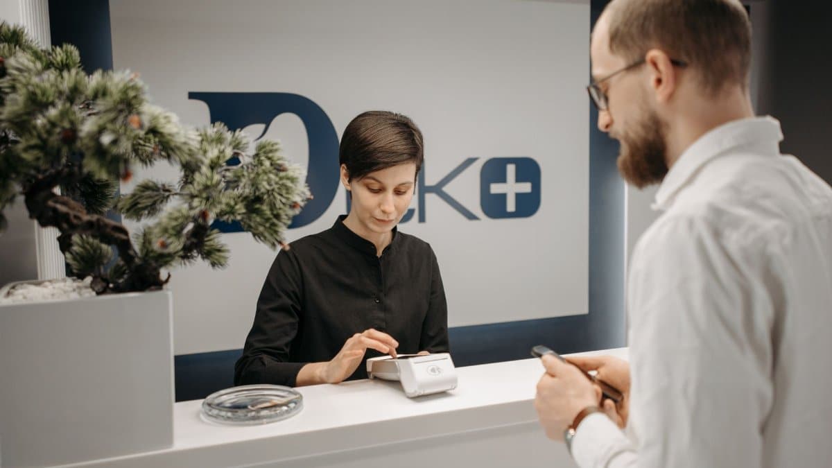 Customer makes a cashless payment at a clinic reception using wireless technology.