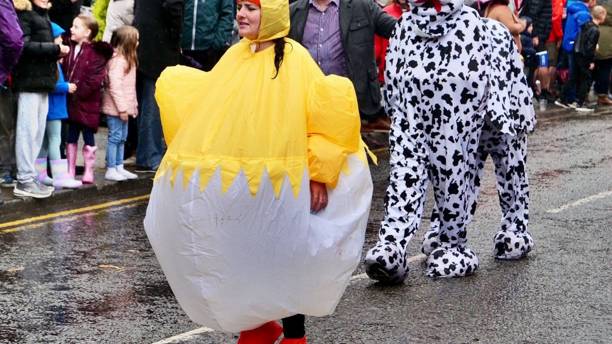 Participants in vibrant costumes parade through Knaresborough during the annual bed race event.