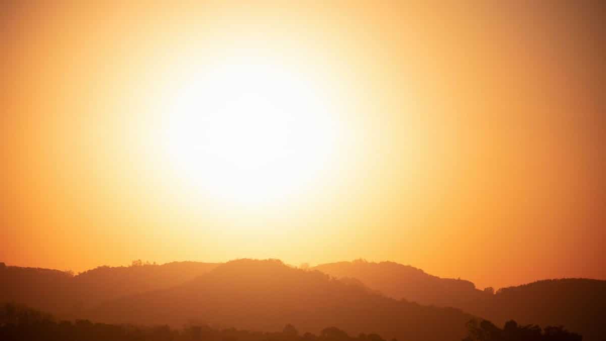 Silhouette of mountains under a bright sunset with a golden sky.