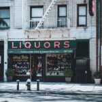 Vintage New York City liquor store facade with architectural details on a sunny day.