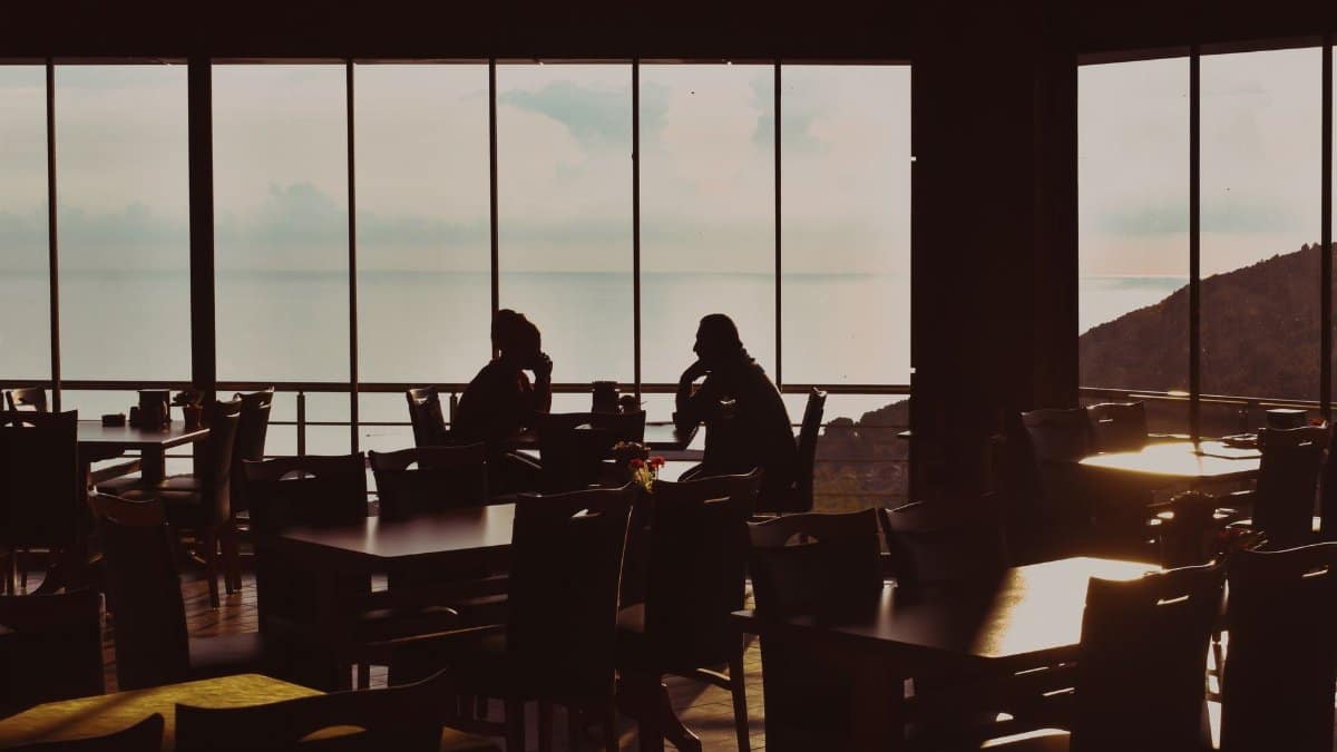 A serene sunset view from a seaside restaurant in Cide, Turkey, capturing silhouettes enjoying the evening.