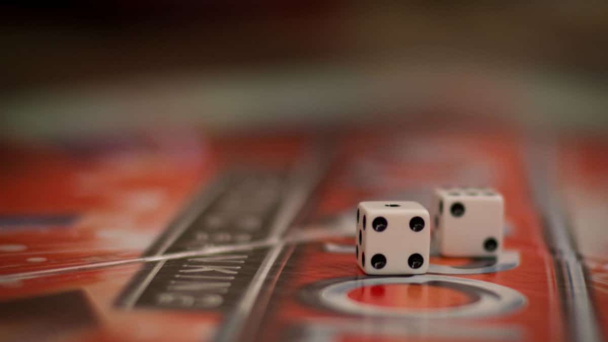 Two dice resting on a colorful board game surface, symbolizing chance and strategy.