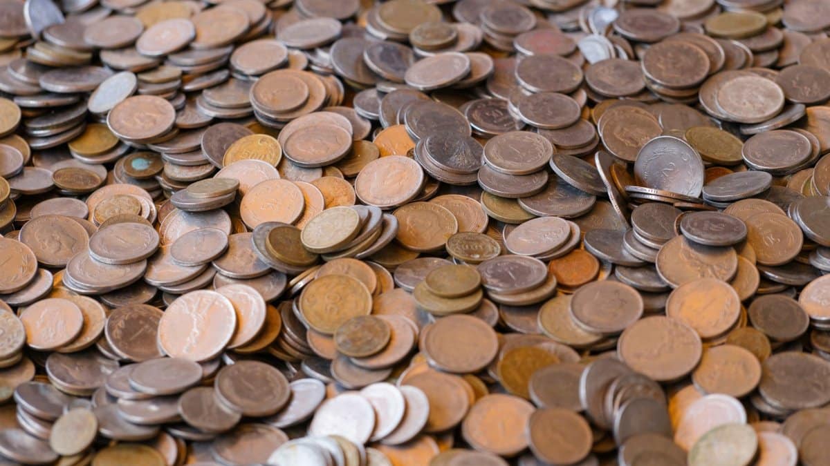 A large pile of mixed coins representing wealth and financial concepts.