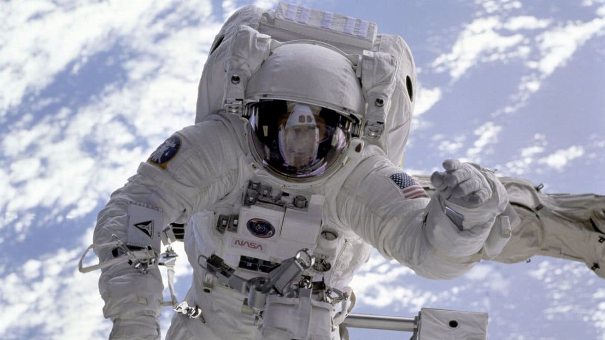 Astronaut conducting a spacewalk with Earth in the background, showcasing outer space exploration.
