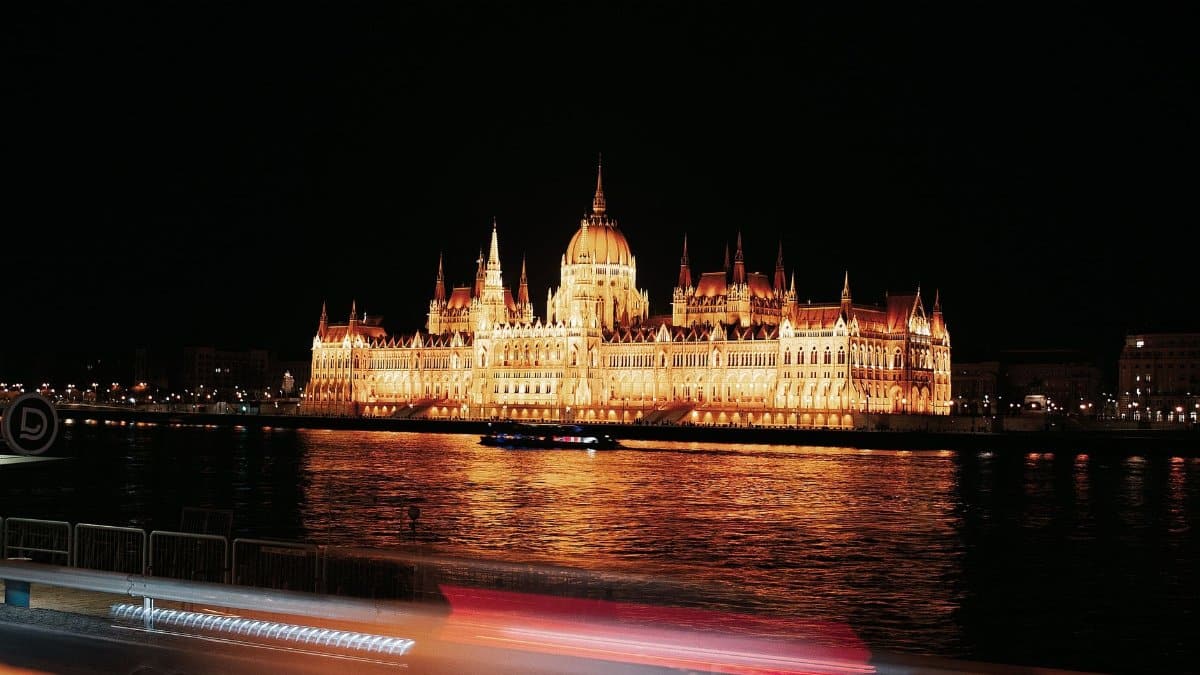Stunning night view of the illuminated Hungarian Parliament Building reflecting on the Danube River.