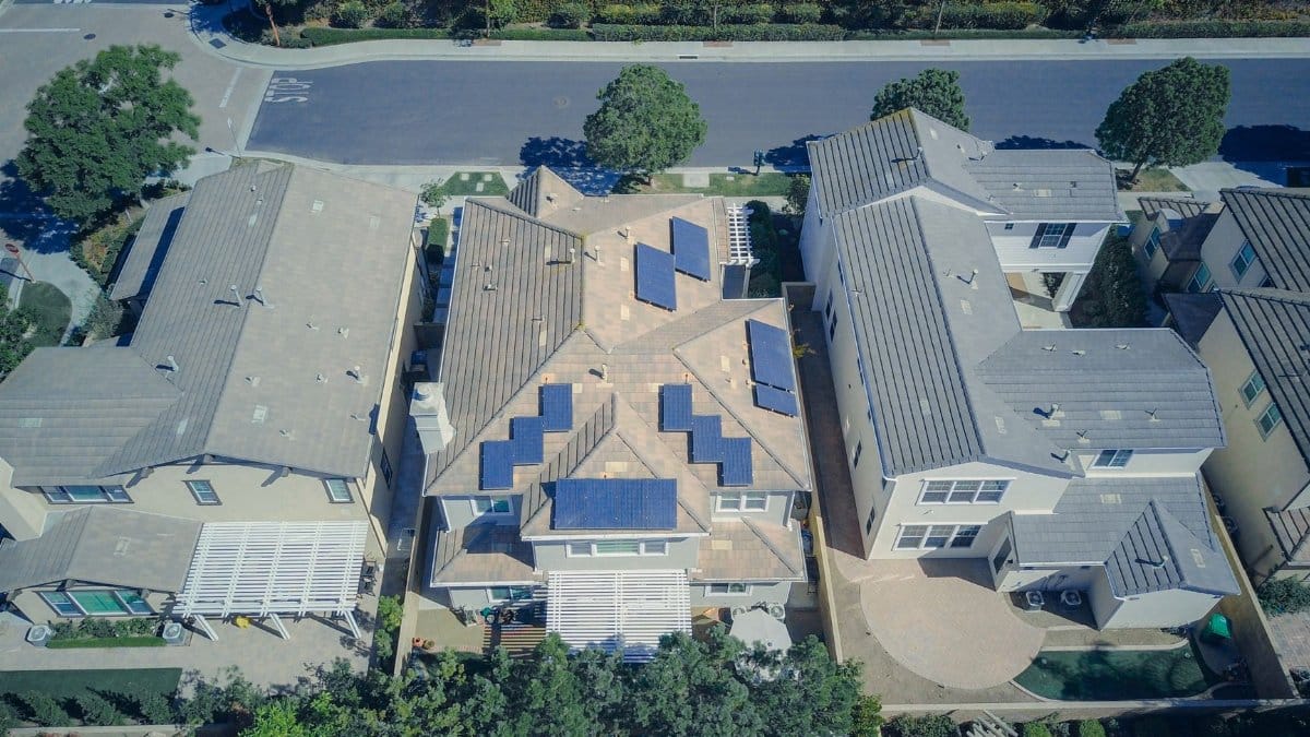 Aerial view of suburban houses equipped with solar panels for renewable energy.