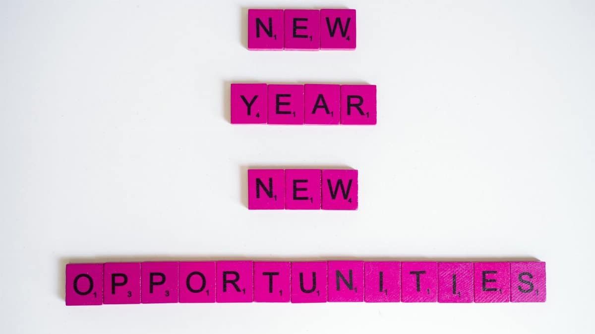 Pink scrabble tiles spelling 'New Year New Opportunities' on white background.