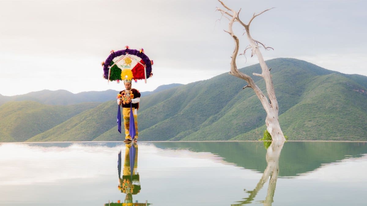 Traditional dancer reflects at Hierve el Agua in Oaxaca, capturing cultural essence and natural beauty.