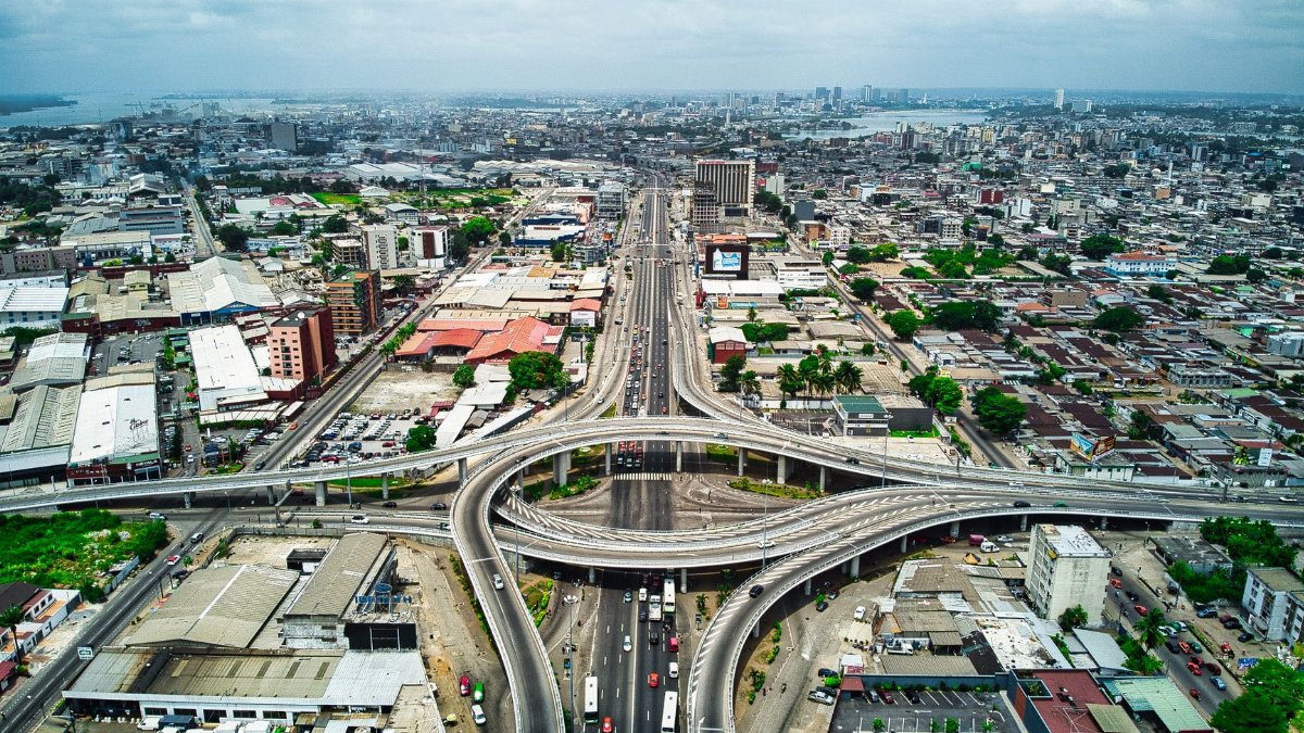 Stunning aerial view of Abidjan's modern expressway and cityscape, showcasing urban development.