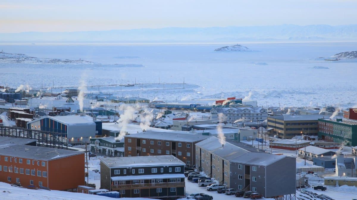 A panoramic winter view of Iqaluit, Nunavut, capturing arctic architecture in a snowy landscape.