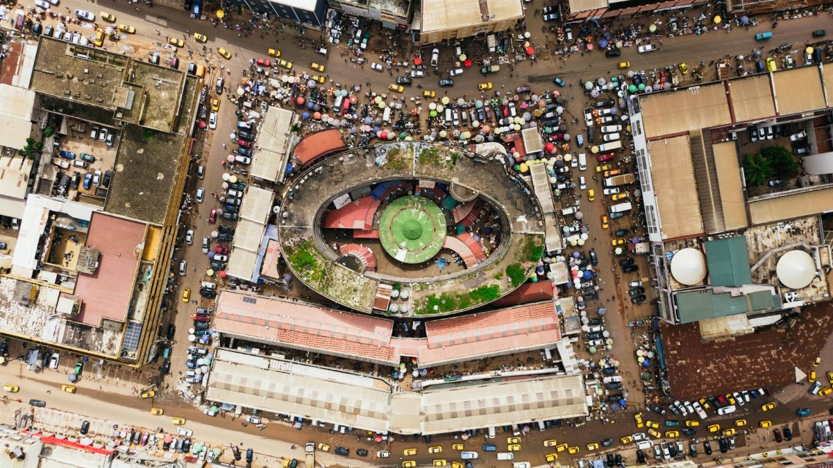 Aerial shot of bustling central market in Yaoundé, Cameroon showcasing busy streets and rooftops.