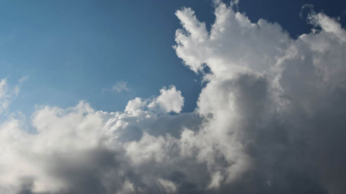 A captivating sky filled with cumulus clouds against a bright blue backdrop, showcasing dynamic weather patterns.
