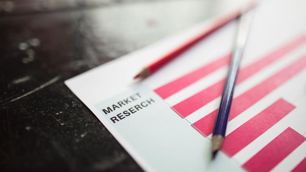 Close-up of market research paper with red graph bars and pencils, emphasizing business analysis.