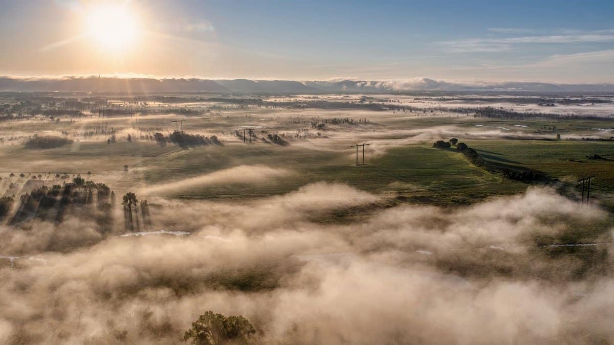 Breathtaking aerial view of sunrise over misty fields in Kellogg, MN showcasing a serene landscape.