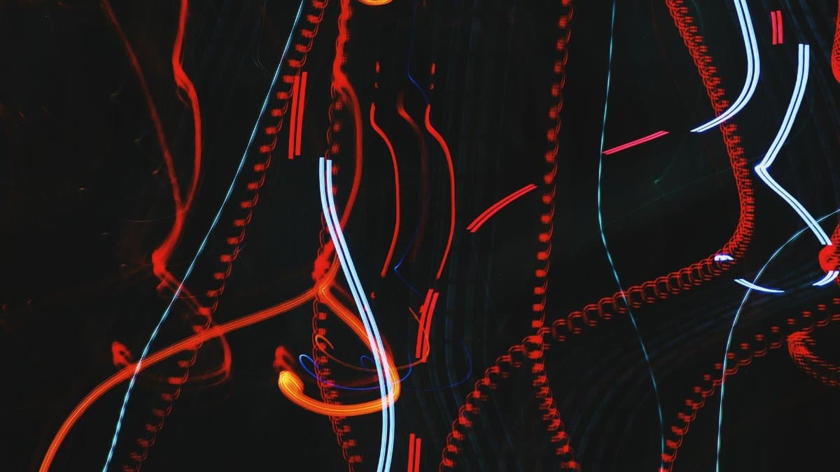 Vibrant abstract light trails featuring red and blue colors in a long exposure nighttime setting.