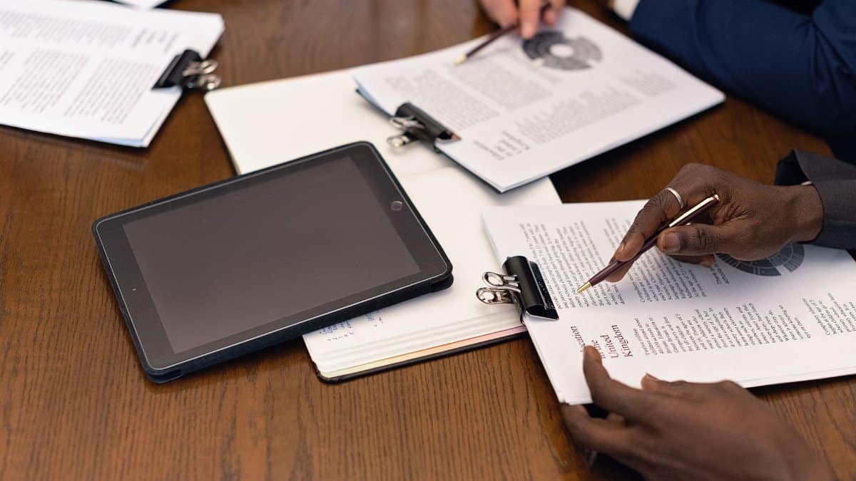 A business meeting with tablets and documents, showcasing digital integration in a professional setting.