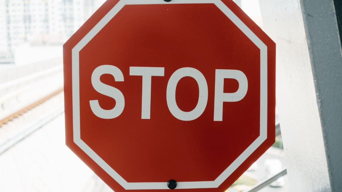 Close-up of a red stop sign with urban background, emphasizing safety and caution.