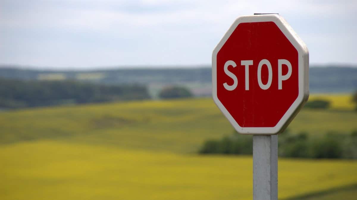 A stop sign stands alone against a rural landscape in Schweyen, France.