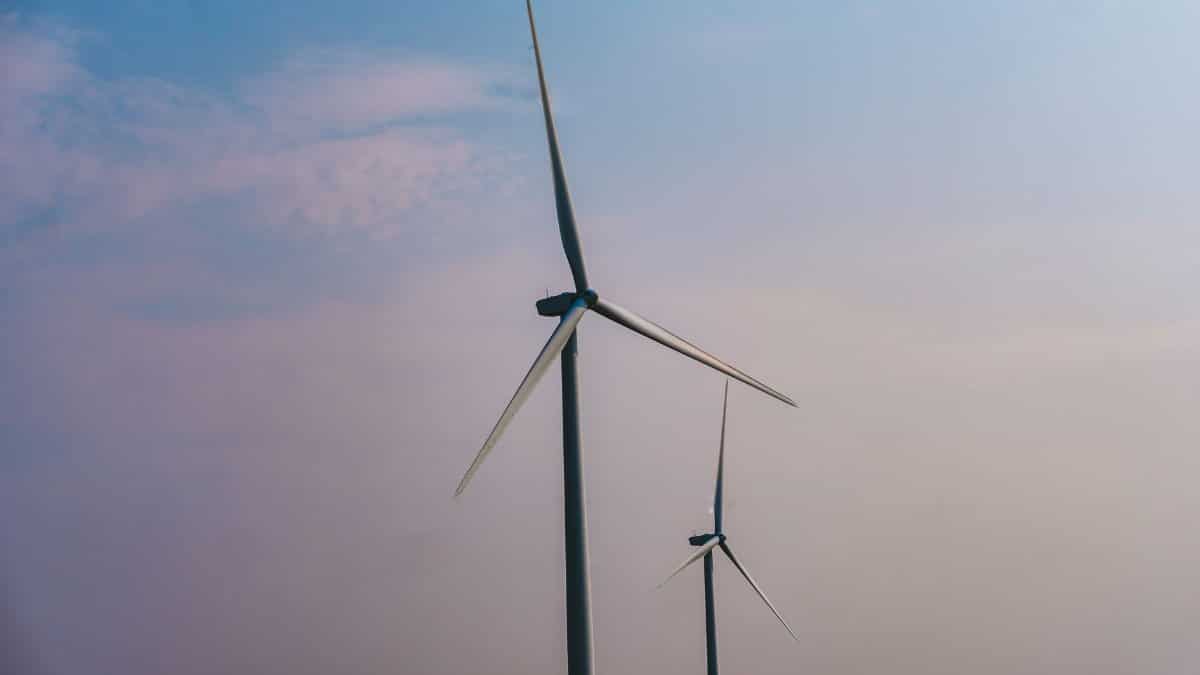 Two wind turbines stand tall under a clear sky, emphasizing renewable energy solutions.