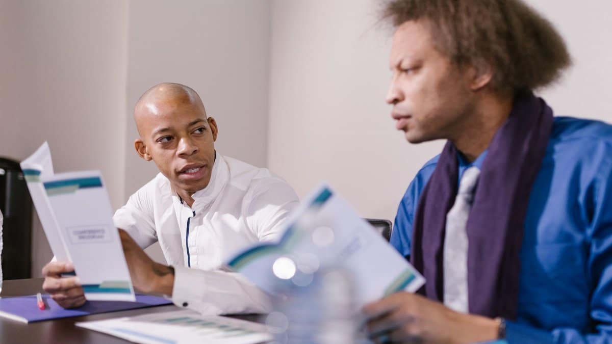 Two professionals engaged in a focused discussion during a business meeting in a conference room.