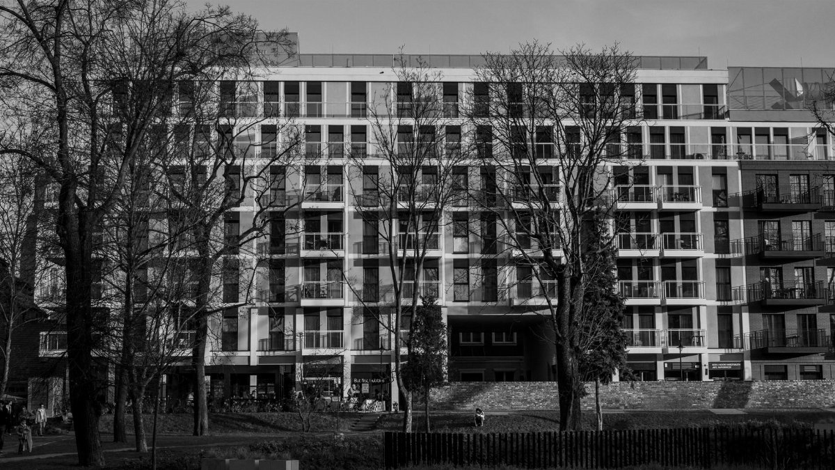 Monochrome view of a contemporary apartment building in a city park.