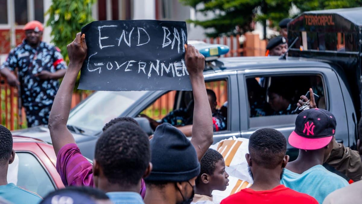 Protesters holding a sign demanding change in Nigeria during a peaceful demonstration.