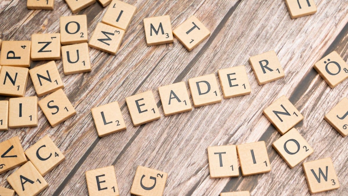 Wooden Scrabble tiles on a table spelling 'Leader' symbolize leadership and strategy.
