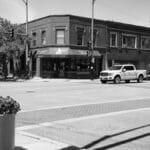 Urban intersection in Chicago with historic buildings and vehicles in monochrome style.