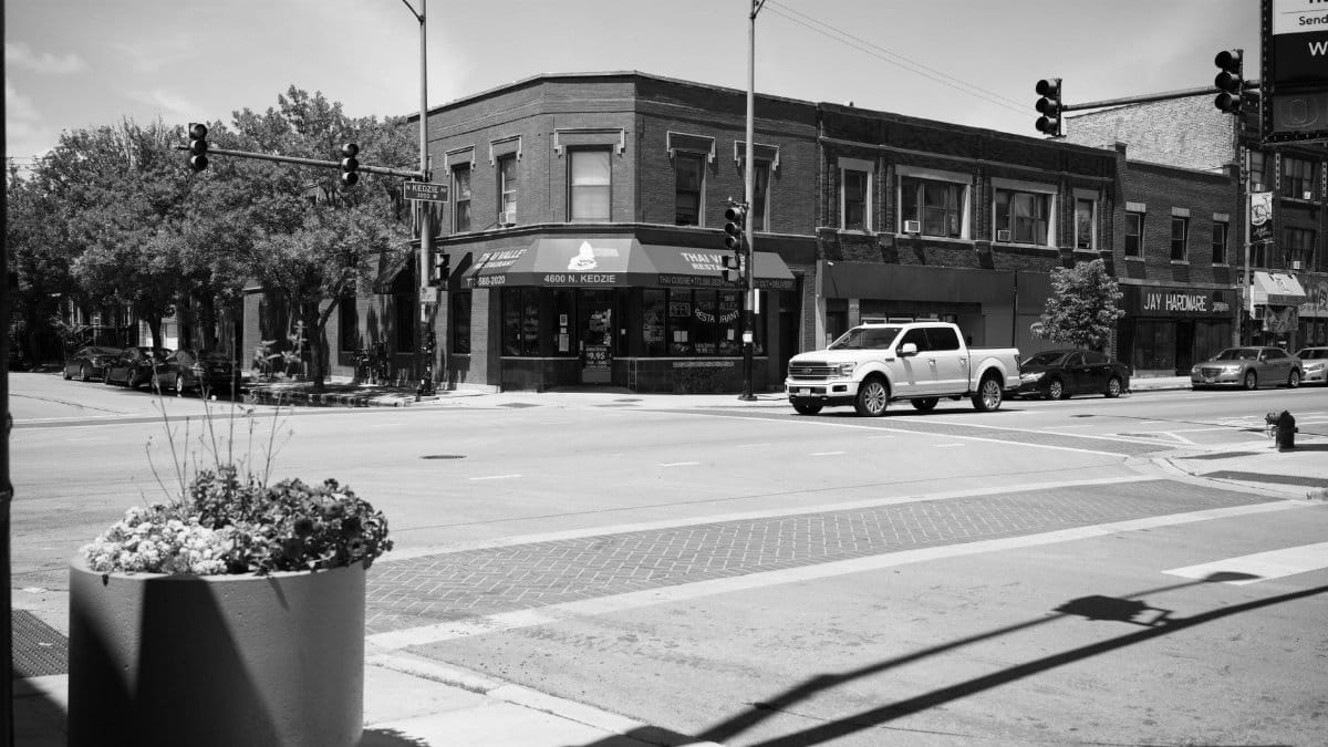 Urban intersection in Chicago with historic buildings and vehicles in monochrome style.