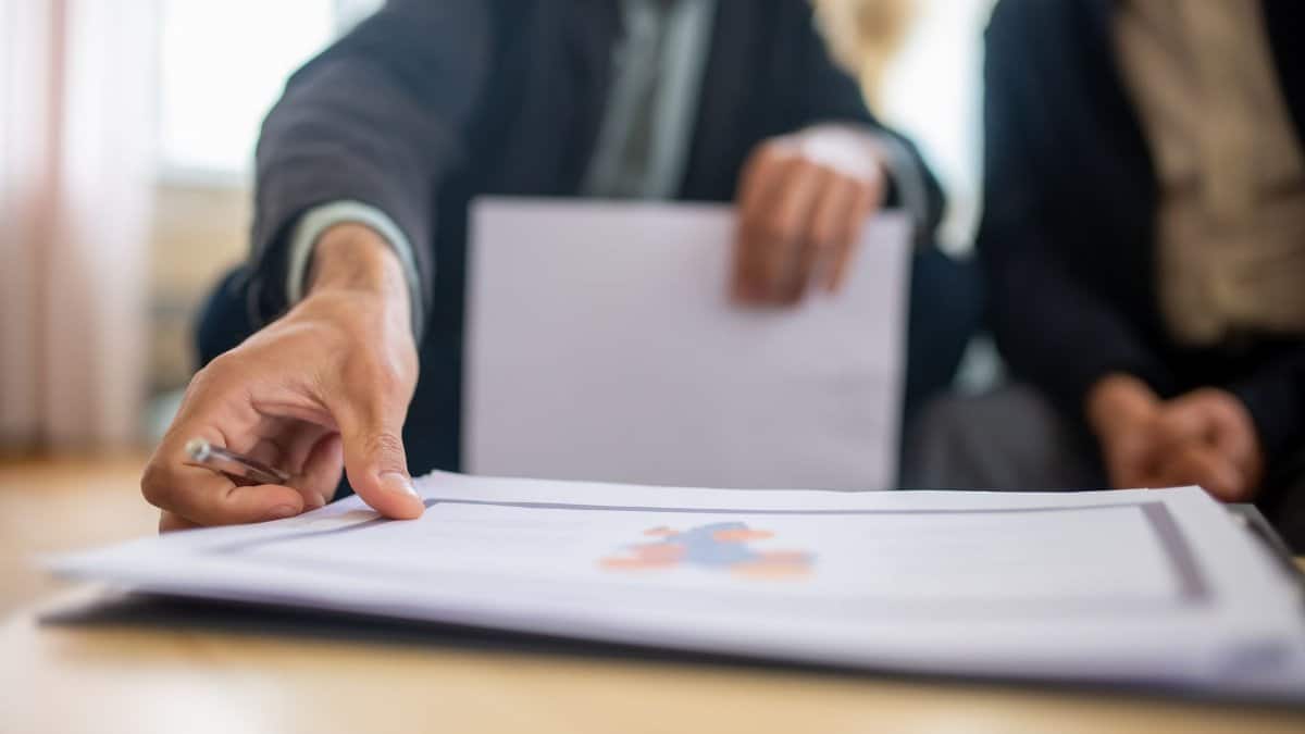 Close-up of a businessman reviewing important documents at a desk in an office setting.