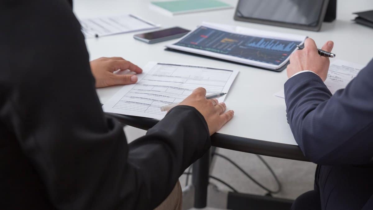Close-up of professionals reviewing documents in an office setting, focused on analytics.