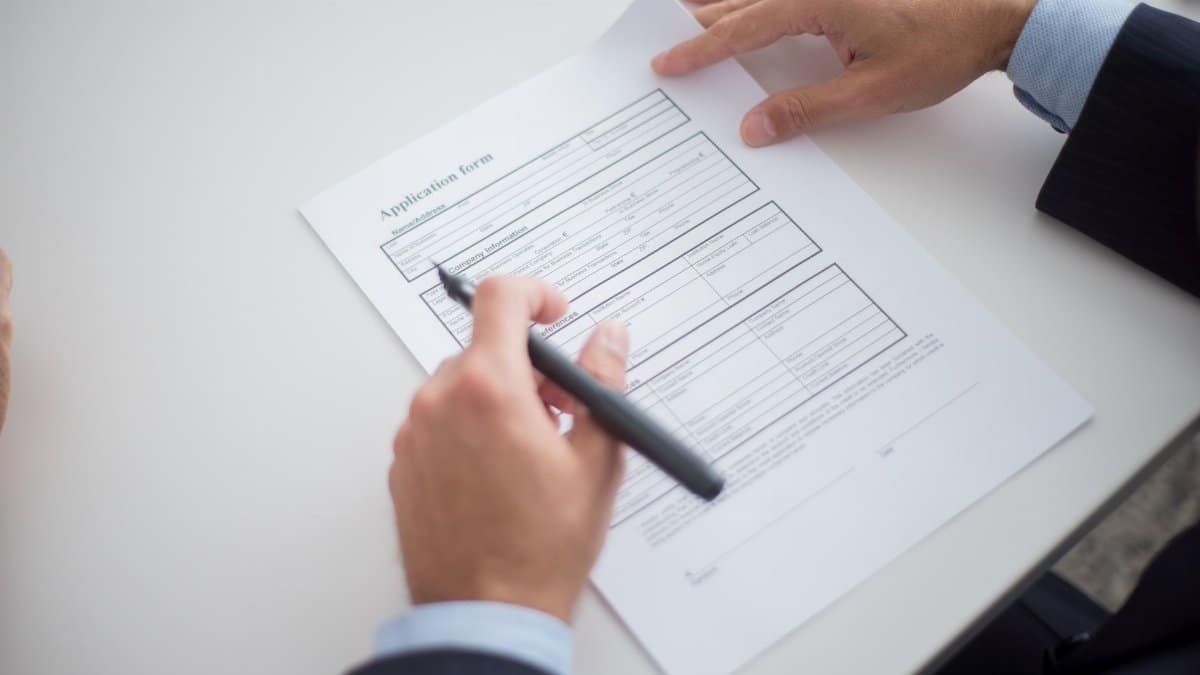 Close-up of a business professional reviewing an application form at a desk.