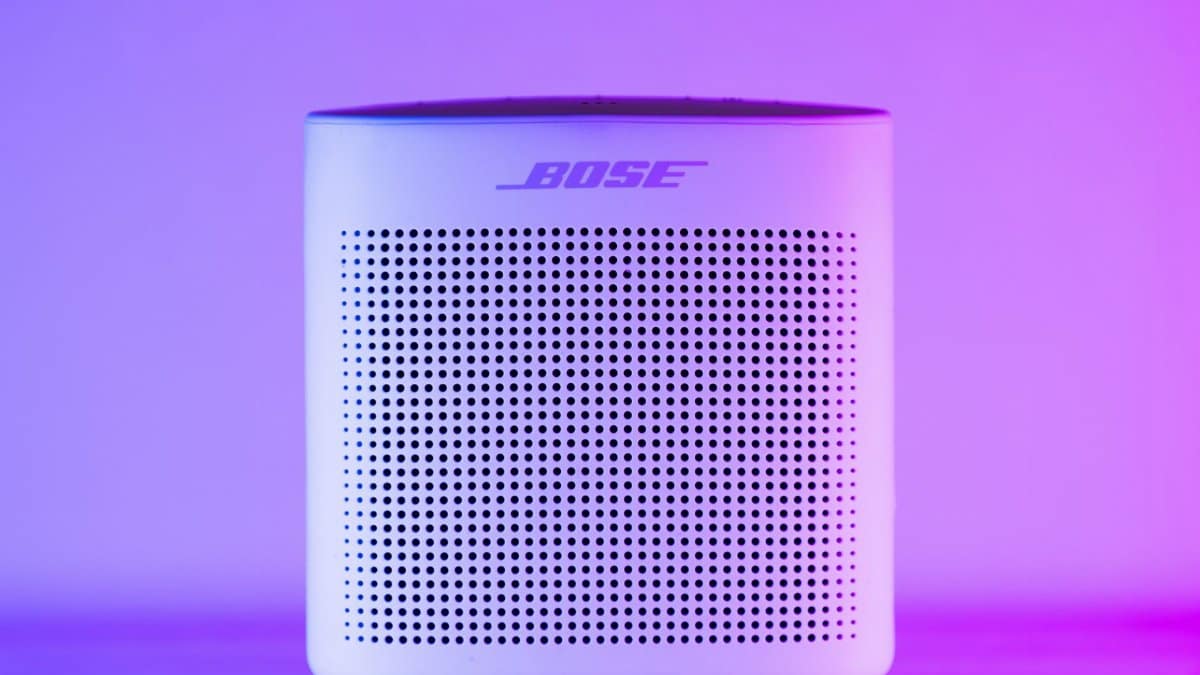 A sleek, modern Bluetooth speaker with a purple and blue light gradient, perfect for home audio setups.
