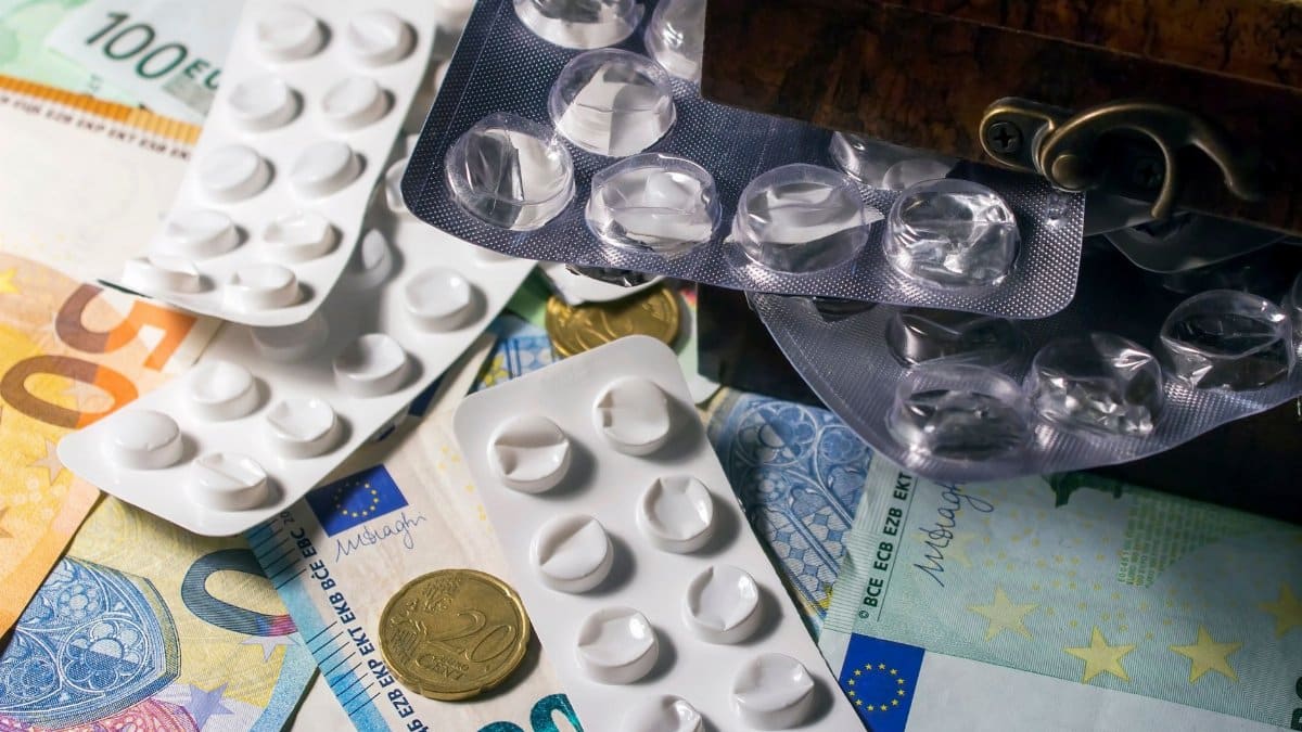 Blister packs of medication placed on Euro banknotes, illustrating healthcare expenses.