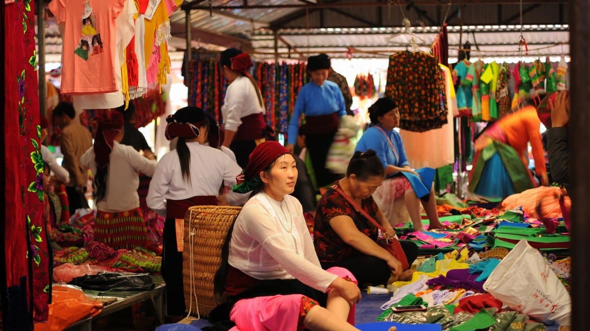 Lively scene at a traditional market showcasing colorful clothing and local vendors.