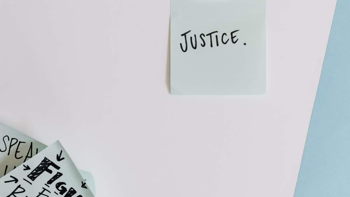 Sticky notes with messages on justice and rights on a flat surface.