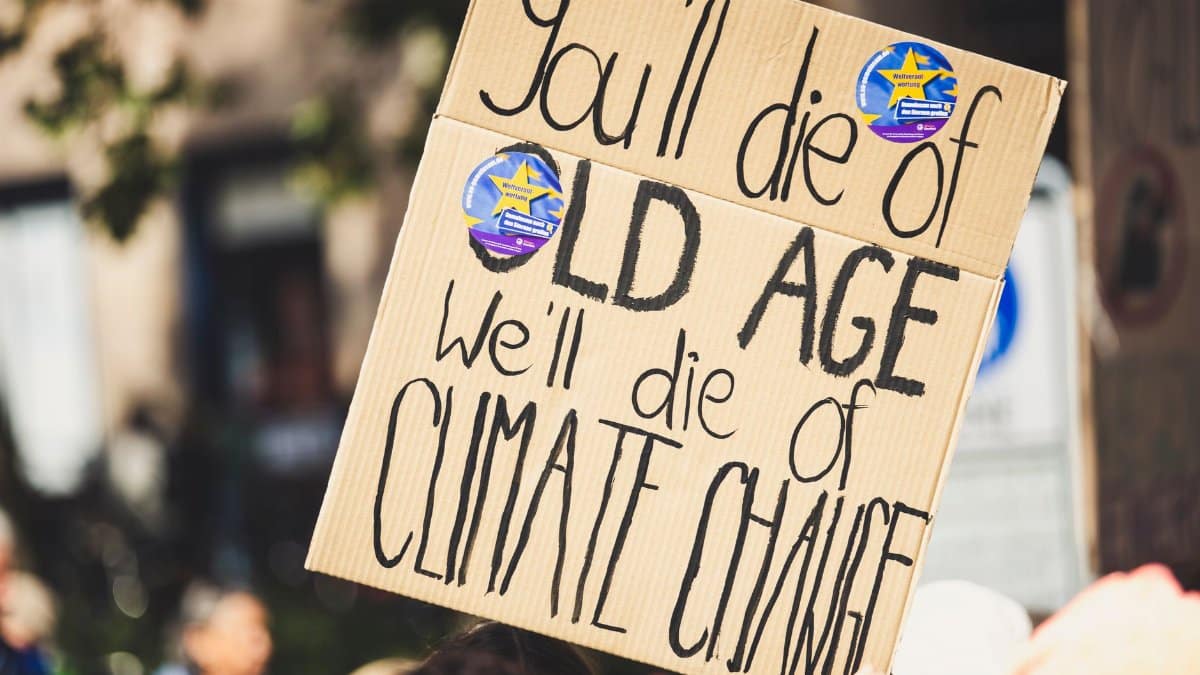 A protest sign highlighting climate change issues during a daylight rally.