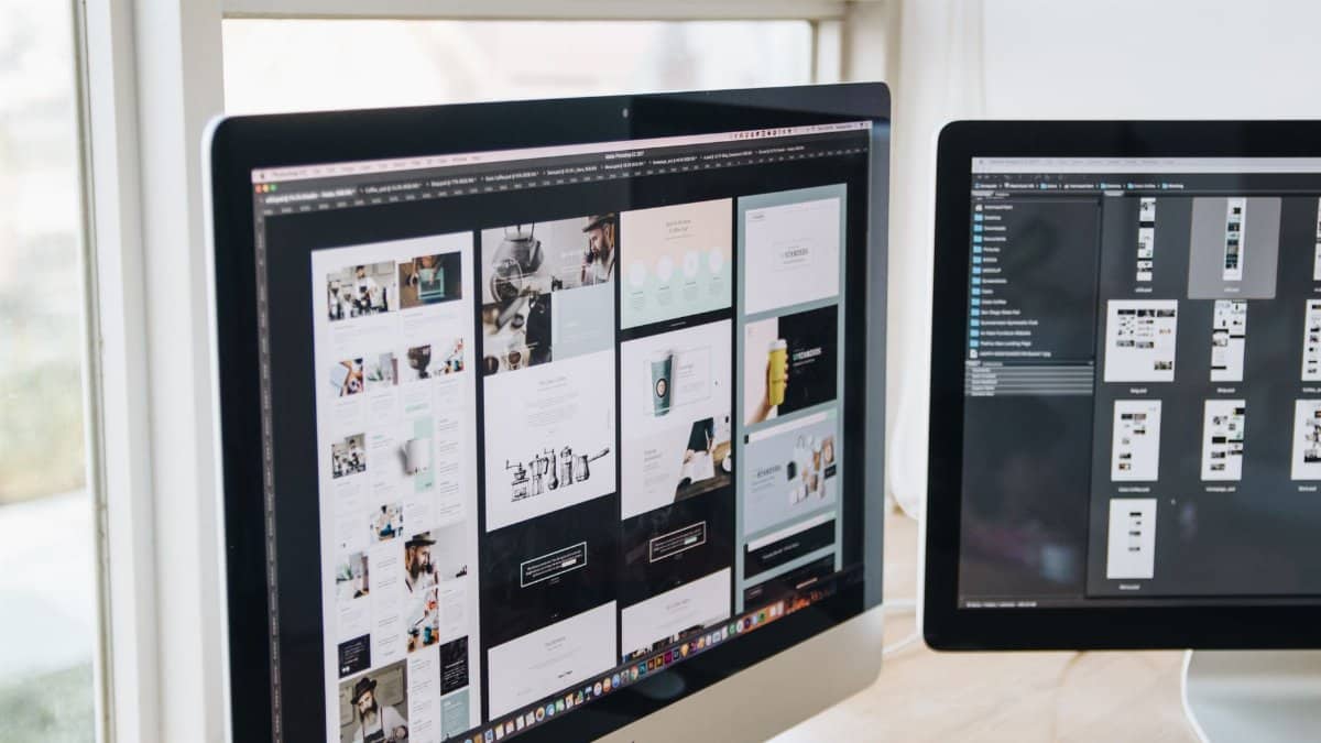 Modern office desk setup with dual monitors displaying design software, ideal for tech and business themes.