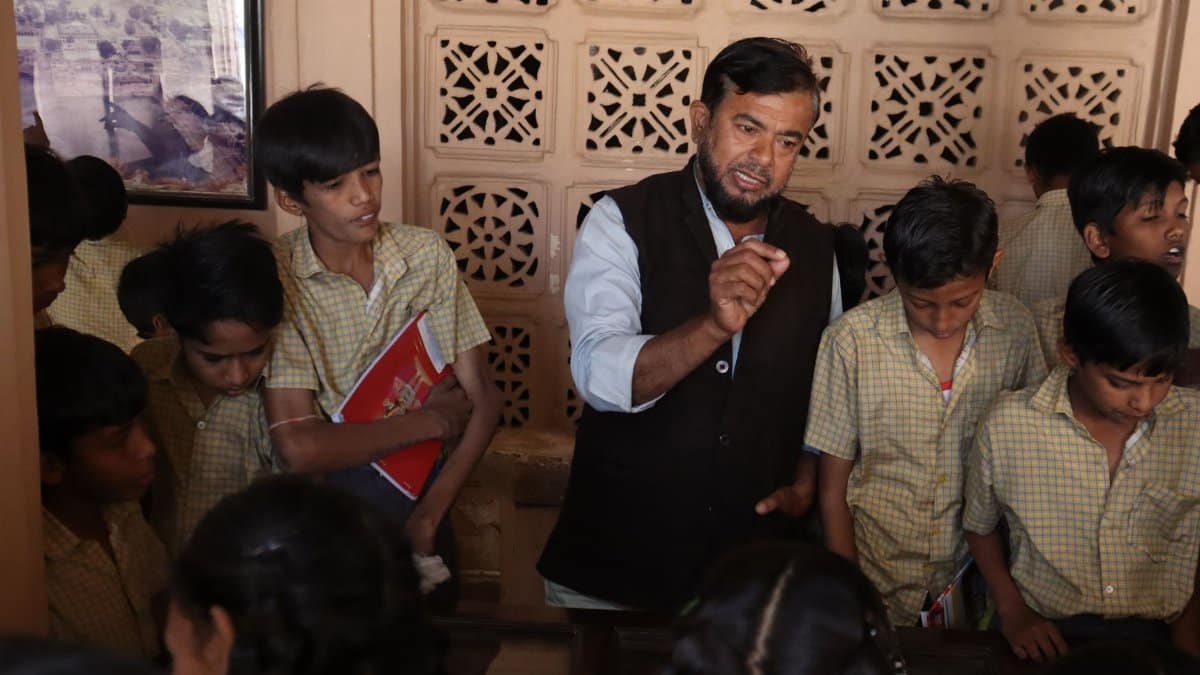 Teacher guiding attentive students during an interactive indoor lesson, fostering education.