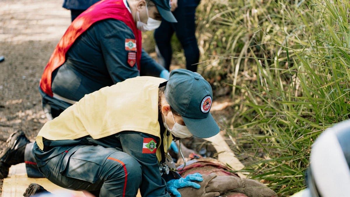 Emergency responders perform a life-saving simulation outdoors, demonstrating teamwork and first aid skills.
