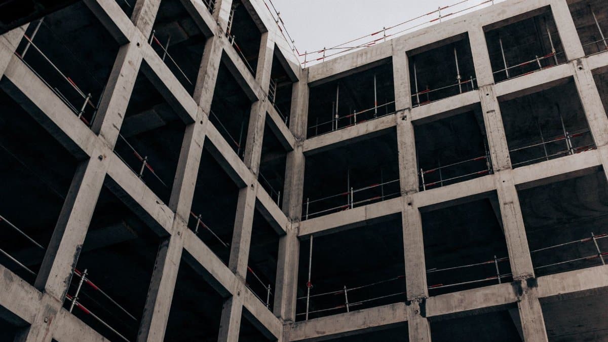 A low angle view of a modern concrete building under construction, showcasing its structure and design.