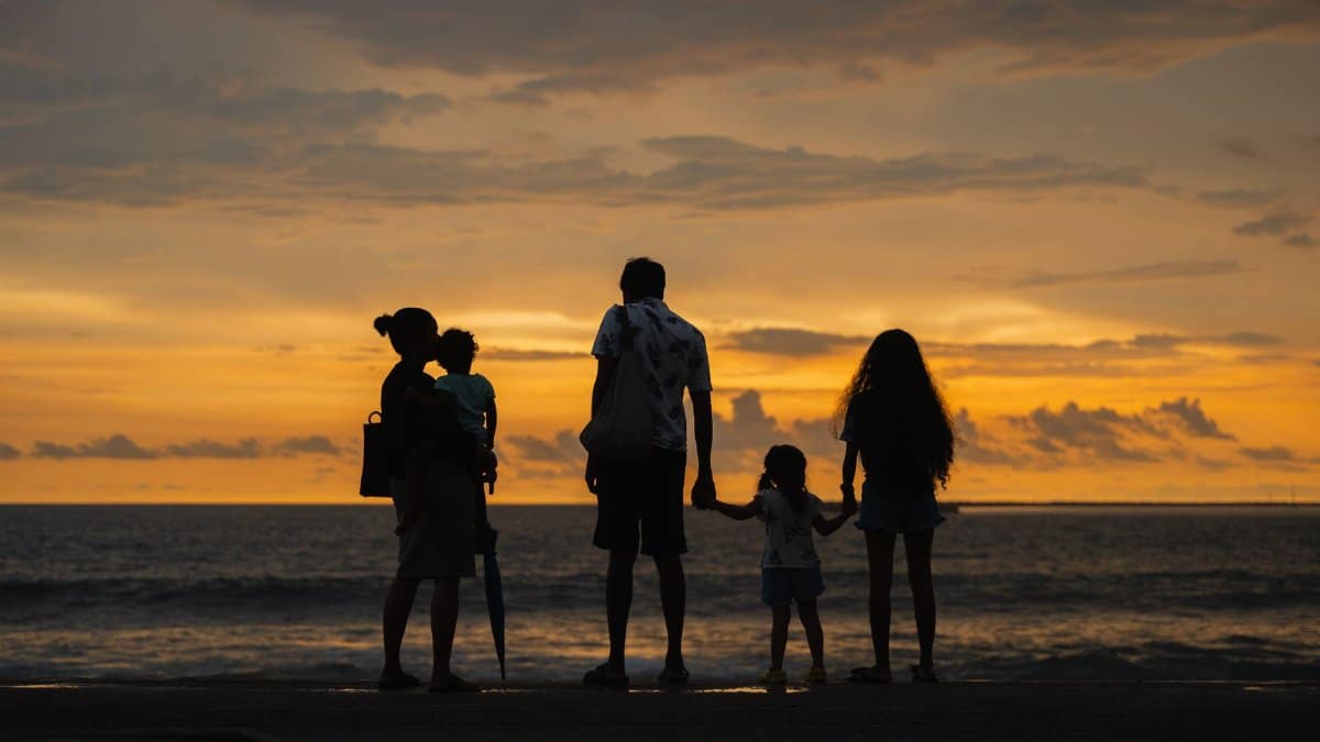 A family enjoying a serene sunset by the ocean at Colombo beach, Sri Lanka.